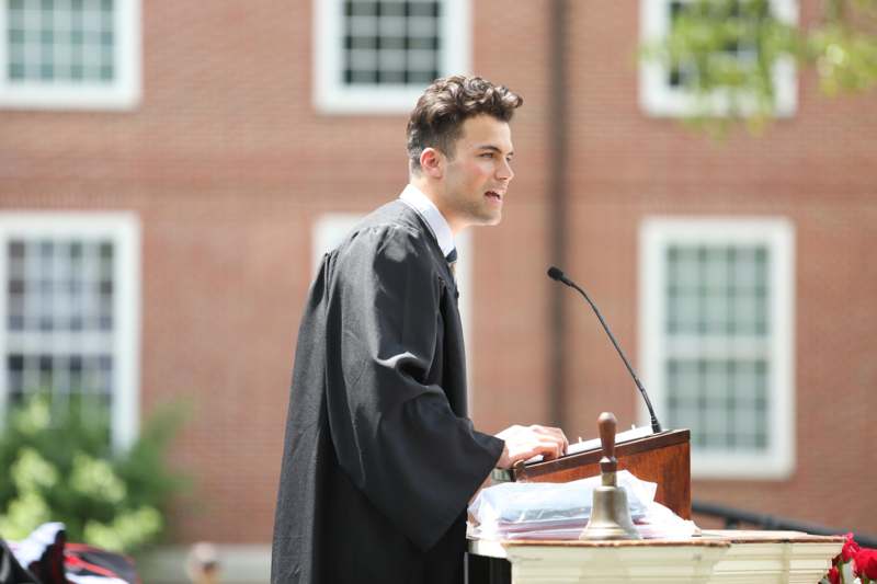 a man in a robe standing at a podium