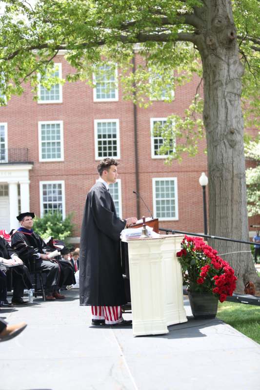 a man in a robe standing at a podium