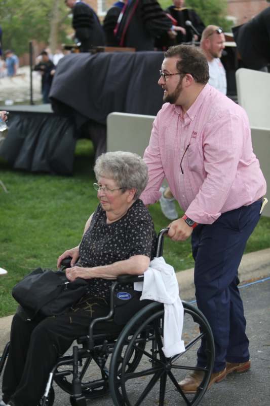 a man pushing an old woman in a wheelchair