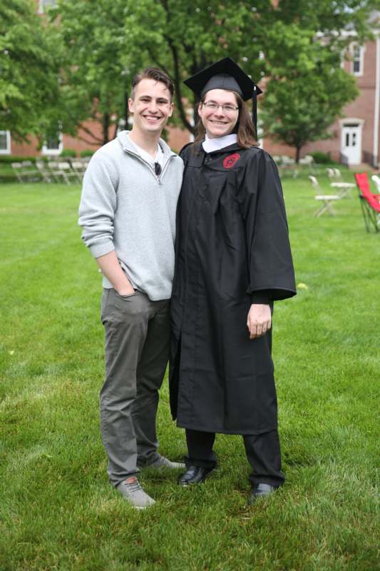 a man and woman standing in a graduation gown