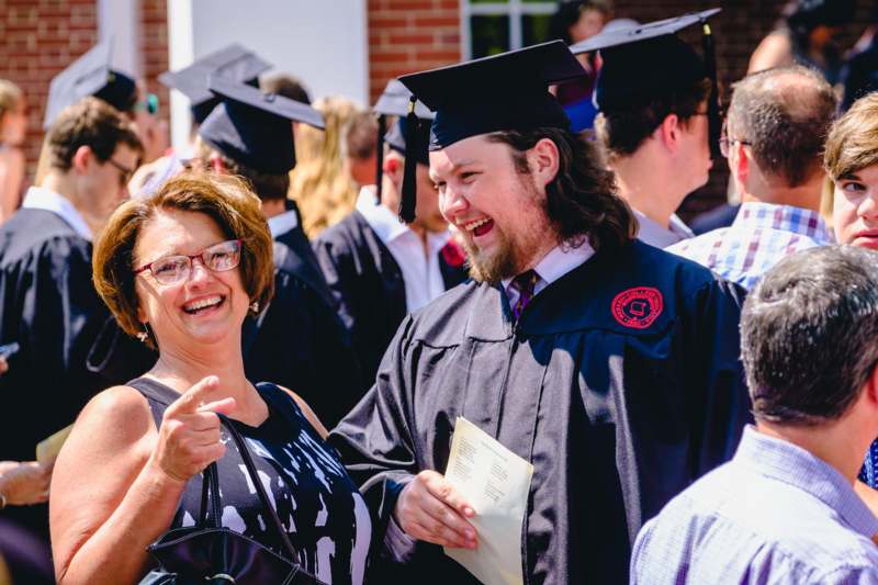 a man in cap and gown with a woman in the middle