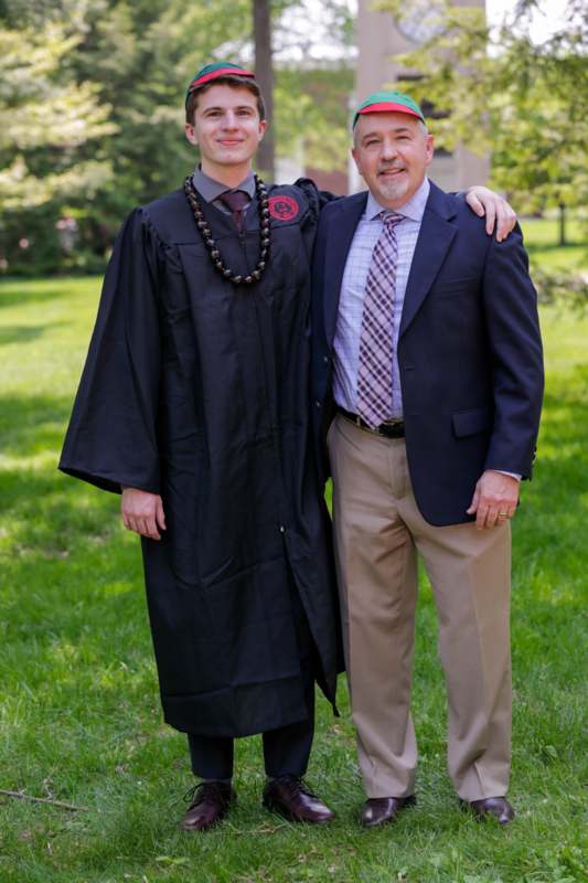 a man in a graduation gown and a man in a suit
