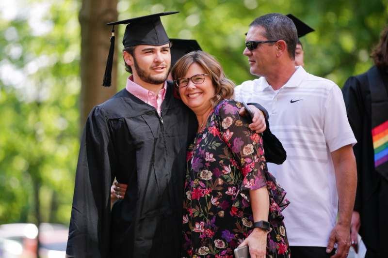 a man in a cap and gown hugging a woman