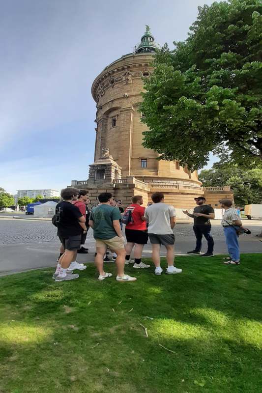 a group of people standing in front of a stone tower