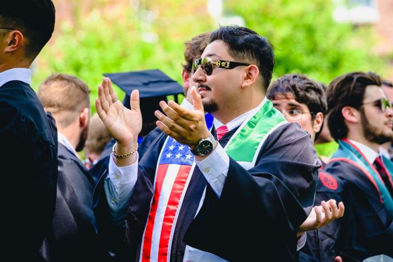 a man in a graduation gown clapping