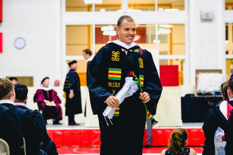 a man in a black robe holding a white object