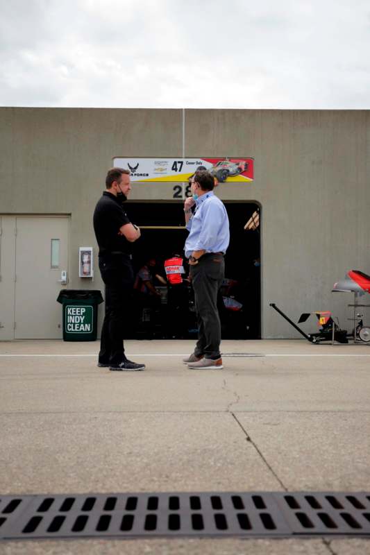 two men standing in front of a garage