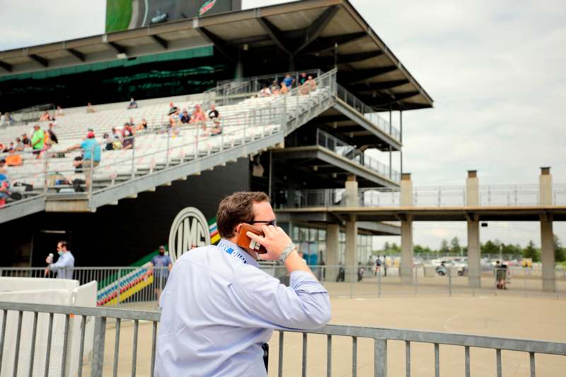 a man talking on a cell phone in front of a stadium