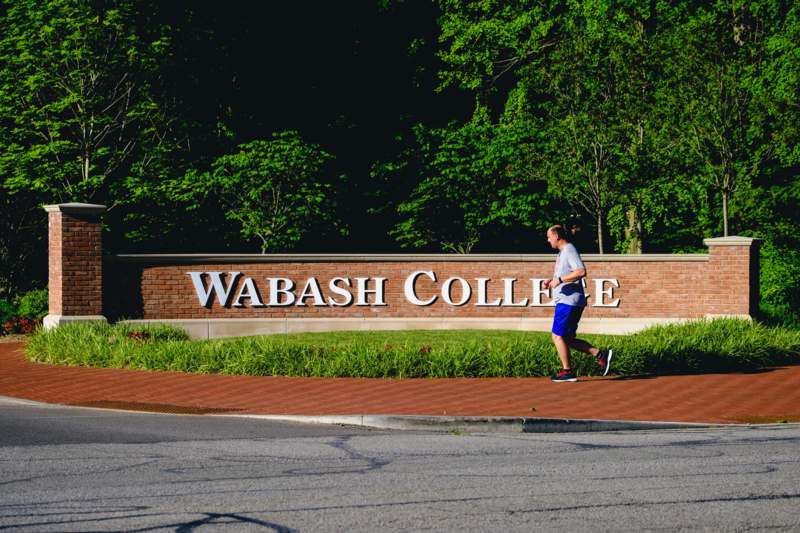 a man running on a brick path near a sign