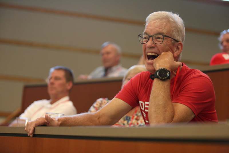a man laughing in a lecture hall