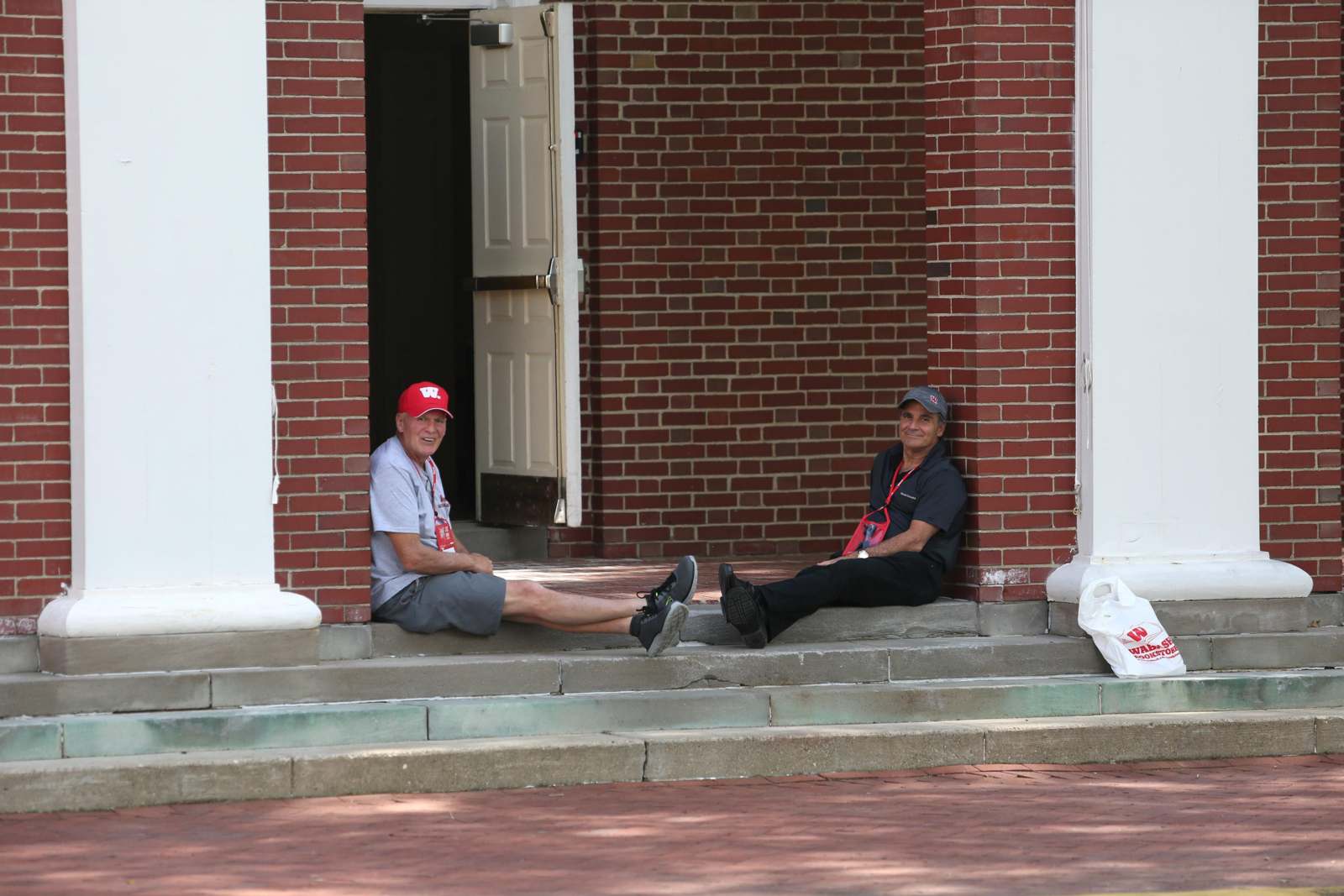 two men sitting on steps outside a building
