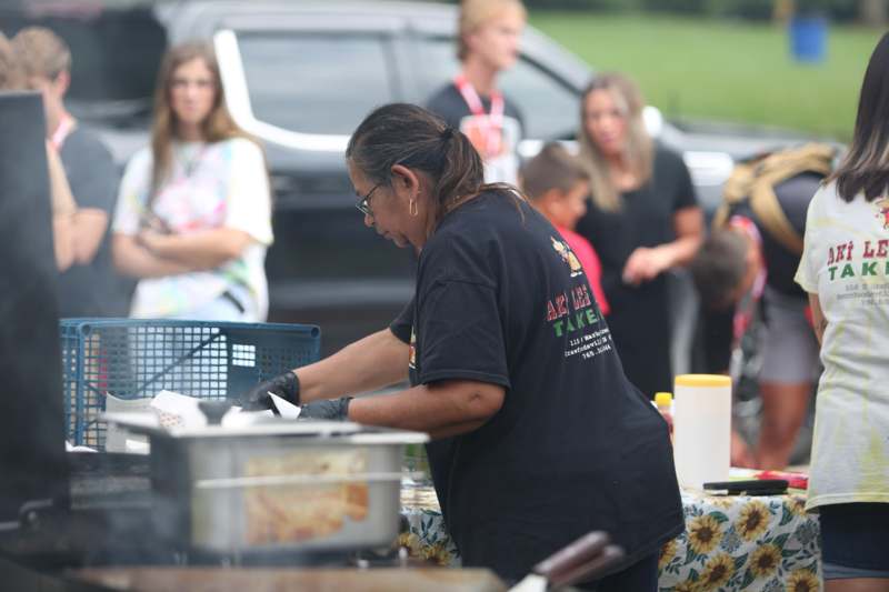 a woman preparing food at a picnic
