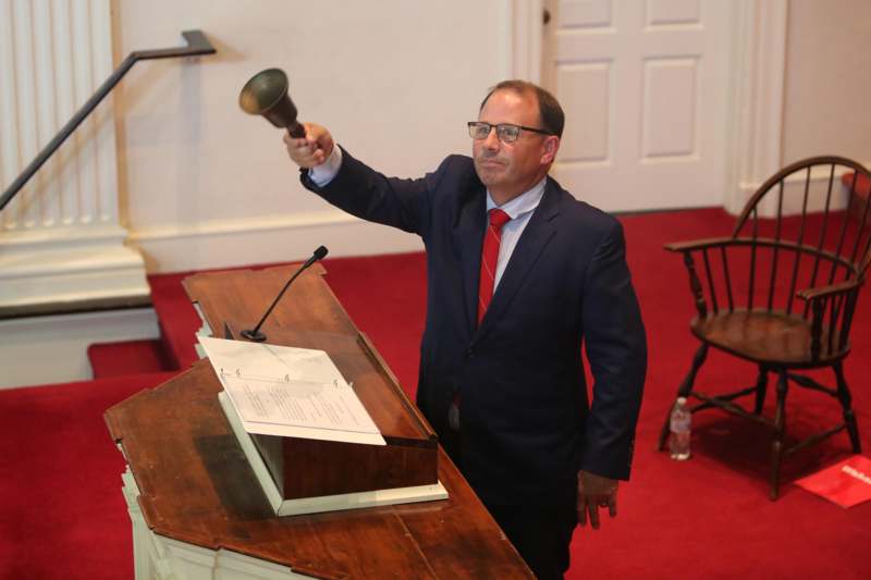 a man in a suit holding a bell