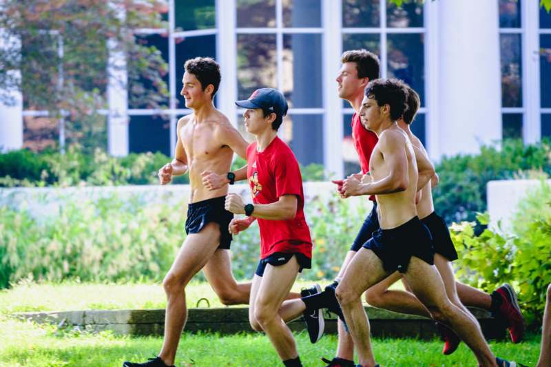 a group of men running in a grassy area