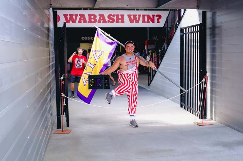 a man in striped pants holding a flag and a banner