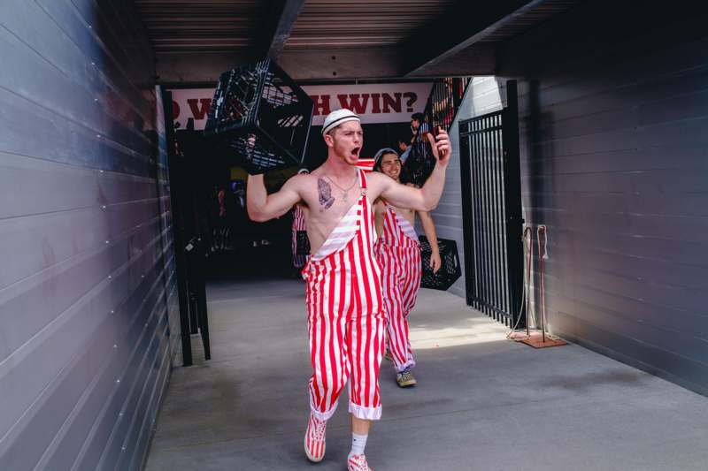 a man in striped overalls holding crates