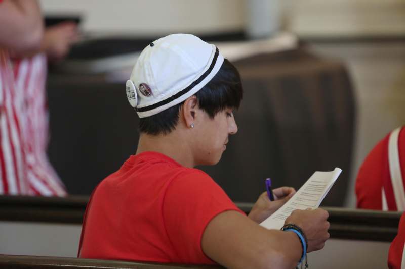 a person sitting in a chair writing on paper