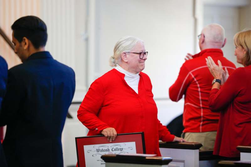 a woman in red shirt standing in front of a man in a red shirt