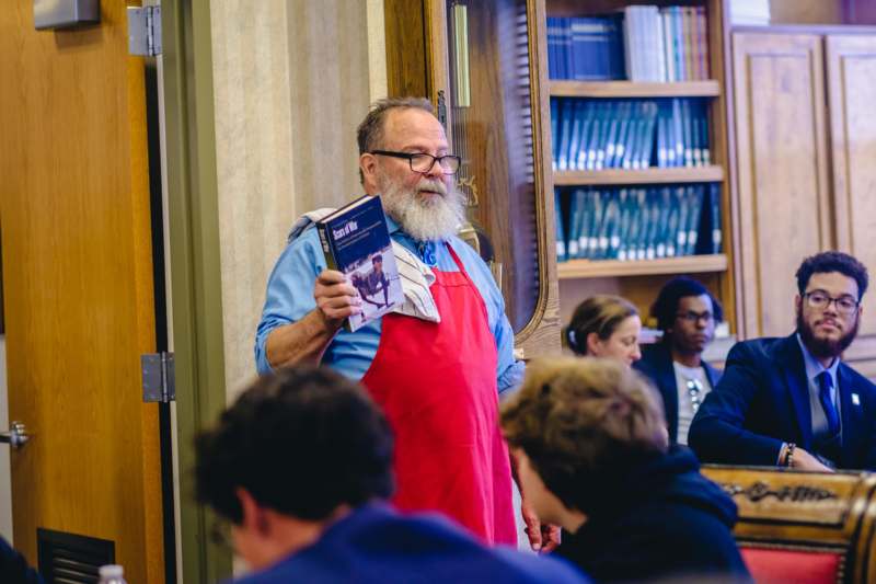 a man in an apron holding a book