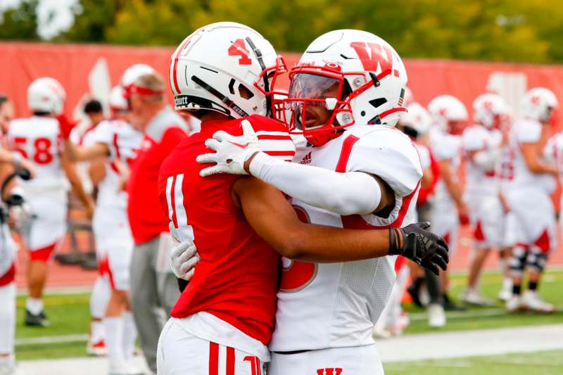two football players hugging on a field