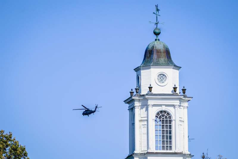 a helicopter flying over a white tower