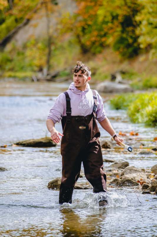 a man in overalls standing in water