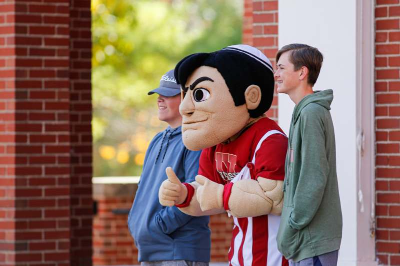 a group of people standing next to a mascot