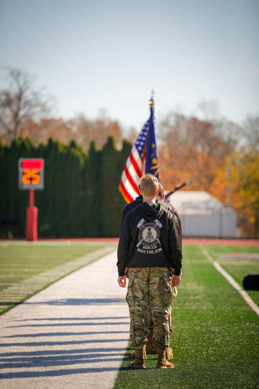 a man in military uniform walking on a football field