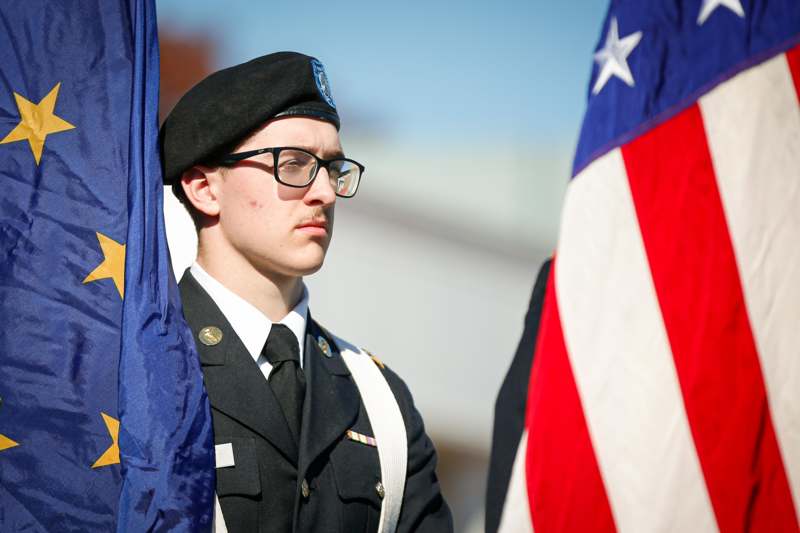 a man in uniform standing next to a flag