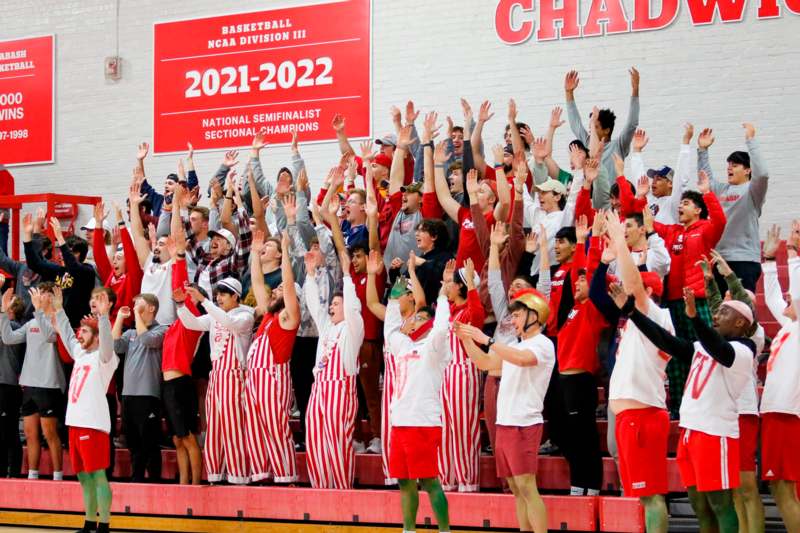 a group of people in red and white uniforms raising their hands