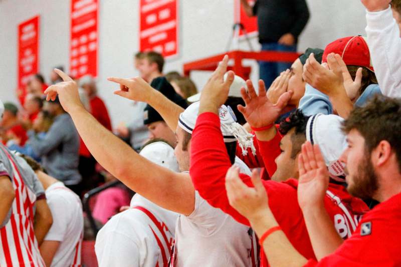 a group of people in a gym raising their hands