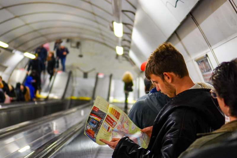 a man reading a map on an escalator