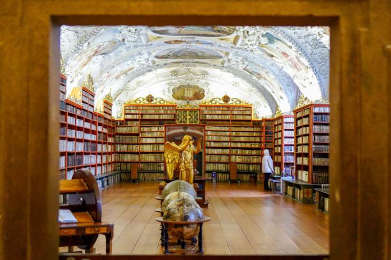 a room with bookshelves and a statue in it