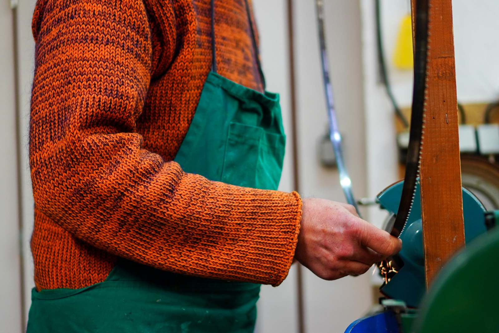 a person in an orange sweater and green apron
