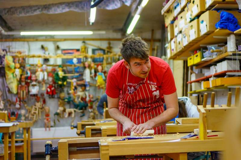 a man in a red shirt working on wood