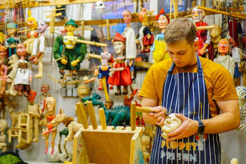 a man in an apron working on a wood carving
