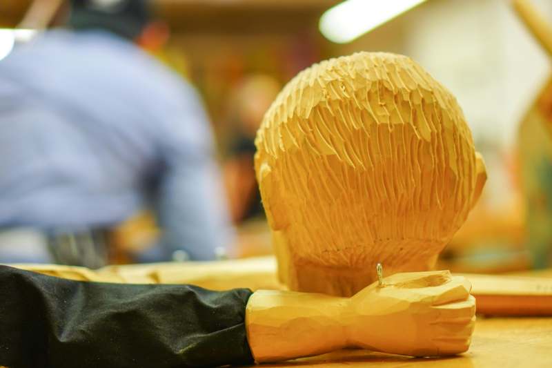 a wooden head with a hand on it