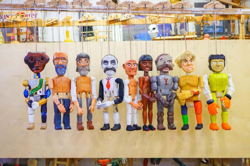 a group of wooden puppets from a wall