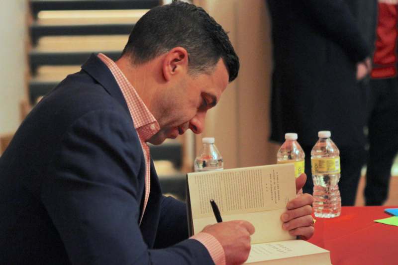 a man in a suit signing a book