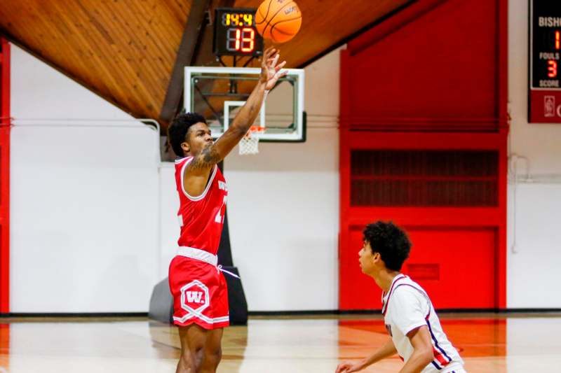 a basketball player in a red uniform jumping to shoot a basketball