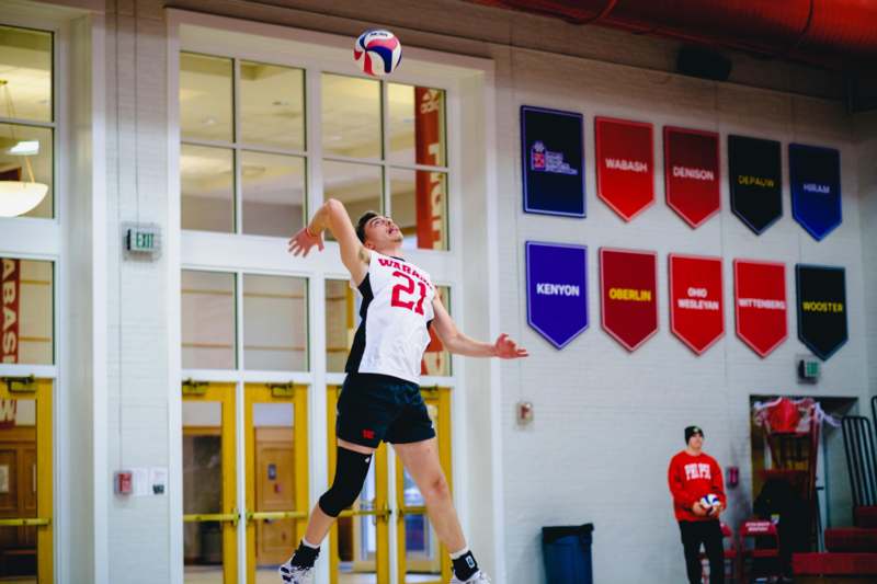 a man jumping in the air to hit a volleyball