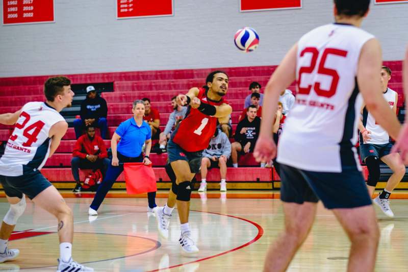 a man in a red shirt playing volleyball