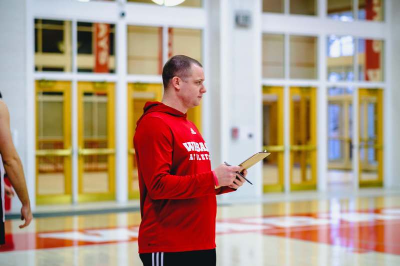 a man holding a clipboard in a gym