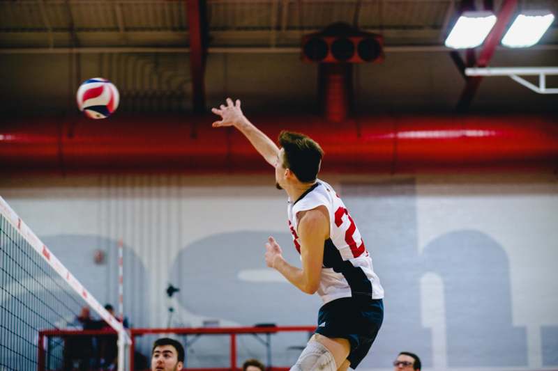a man jumping to hit a volleyball