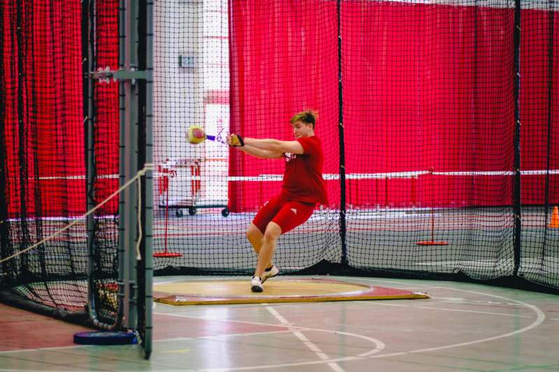 a man swinging a bat in a batting cage