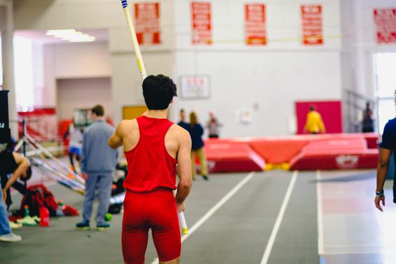 a man holding a pole in a gym