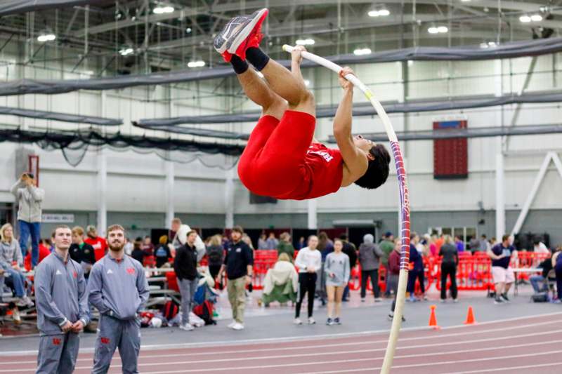 a man in red shorts on a pole in a track
