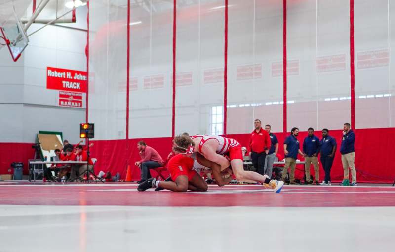 a group of people wrestling on a wrestling mat