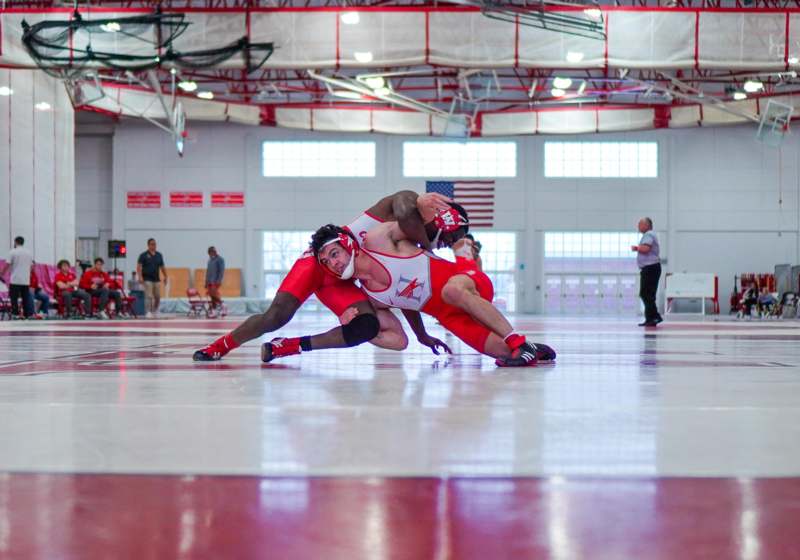 a man wrestling on a gym floor