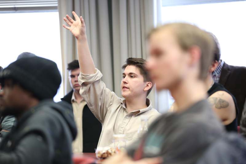 a man raising his hand in a room